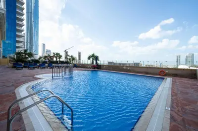 a large swimming pool on the side of a building at Upgraded Stylish Living with Private Steam Room in Dubai