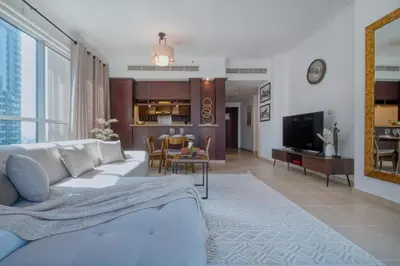 a living room with a white couch and a tv at Cozy 1-Bedroom Apartment at Heart of Dubai in Dubai