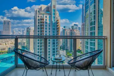 a balcony with two chairs and a view of a city at Cozy 1-Bedroom Apartment at Heart of Dubai in Dubai
