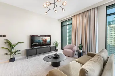 a living room with a couch and a tv at Seaside Lux Retreat 2-BR Private Beach in Dubai