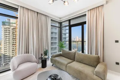a living room with a couch and a large window at Seaside Lux Retreat 2-BR Private Beach in Dubai
