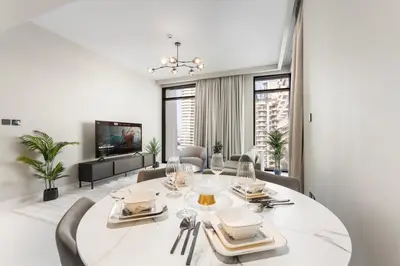 a dining room with a white table and chairs at Seaside Lux Retreat 2-BR Private Beach in Dubai