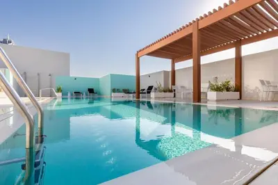 a large swimming pool with blue water in a building at Waves - Refined Studio with Balcony & City Views in Luma21 in Dubai