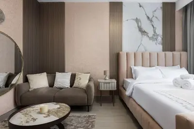 a hotel room with a bed and a couch at Waves - Refined Studio with Balcony & City Views in Luma21 in Dubai