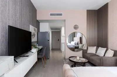 a living room with a television and a couch at Waves - Refined Studio with Balcony & City Views in Luma21 in Dubai