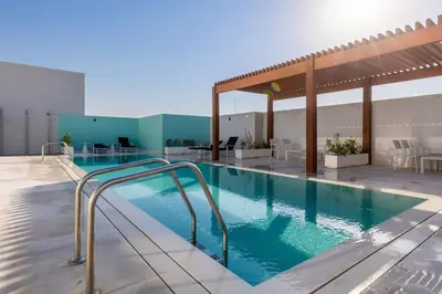 a large swimming pool with a hot tub at Waves - Refined Studio with Balcony & City Views in Luma21 in Dubai