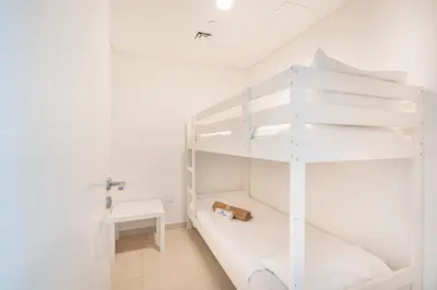 a white bunk bed in a white room at Beautiful Home with Full Burj View in Downtown in Dubai
