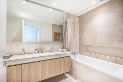 a bathroom with a sink and a tub and a mirror at Beautiful Home with Full Burj View in Downtown in Dubai
