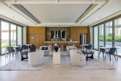 a lobby with tables and chairs and a kitchen at Beautiful Home with Full Burj View in Downtown in Dubai