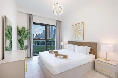 a white bedroom with a large bed and a window at Beautiful Home with Full Burj View in Downtown in Dubai