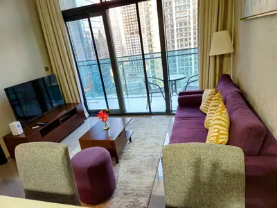 a living room with a purple couch and two chairs at Home away from home in Dubai