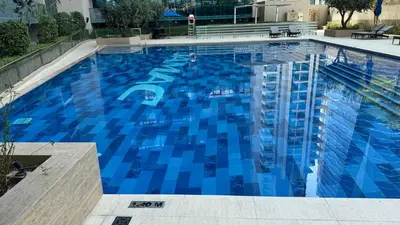 a large swimming pool with blue water at Home away from home in Dubai