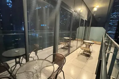 a balcony with tables and chairs on a building at Home away from home in Dubai