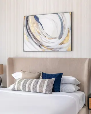 a bedroom with a bed with a painting on the wall at GuestReady - Luxurious nest direct on JBR Beach in Dubai