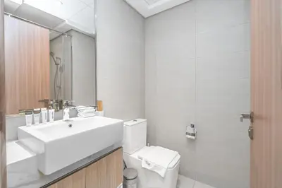 a white bathroom with a sink and a toilet at Escape24 Studio at Azizi Riviera near Business Bay in Dubai