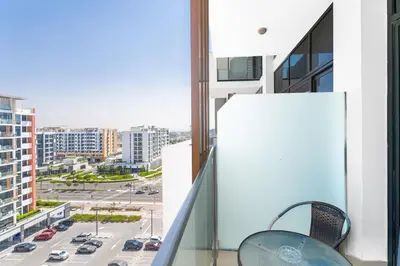 a balcony with two chairs and a view of a city at Escape24 Studio at Azizi Riviera near Business Bay in Dubai