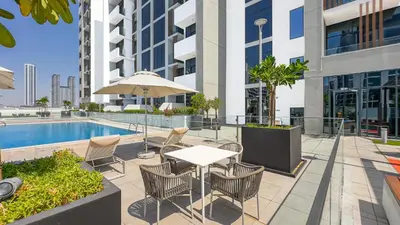 a patio with a table and chairs next to a pool at Escape24 Studio at Azizi Riviera near Business Bay in Dubai