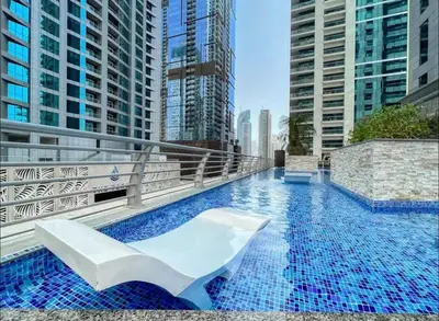 a swimming pool on top of a building with tall buildings at Luxury OneBedroom Apartment next to Barasti Beach in Dubai