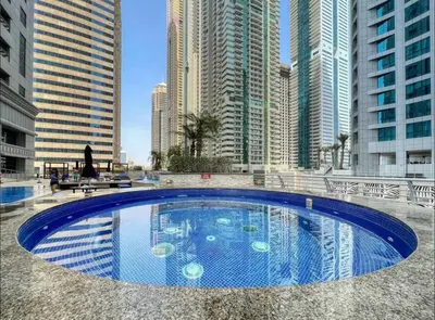 a large swimming pool in a city with tall buildings at Luxury OneBedroom Apartment next to Barasti Beach in Dubai