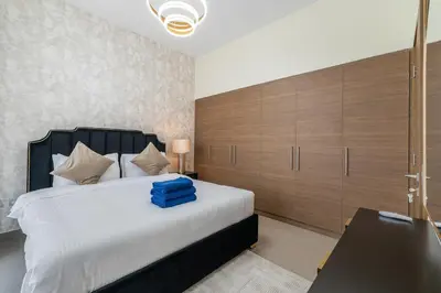 a bedroom with a large bed and wooden cabinets at NewArabian Sidra1 -4 BR & Maid in Dubai