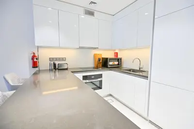 a kitchen with white cabinets and a counter top at Stunning 1BR Retreat with Crystal Lagoon Views! in Dubai