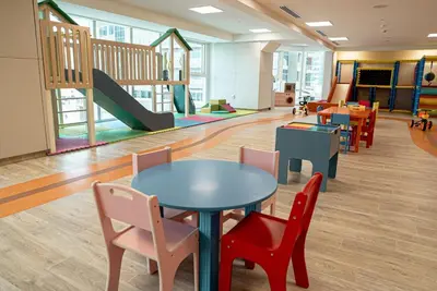 a classroom with tables and chairs and a playground at Stylish Brand New 1 Bedroom in Dubai