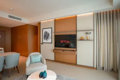 a living room with a chair and a tv at Address Opera 2BR Apartment 54th Floor in Dubai