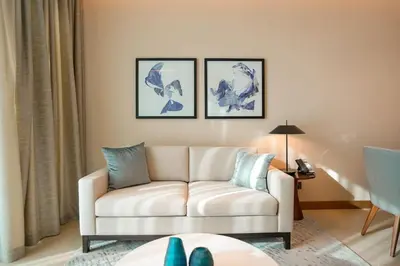 a living room with a white couch and three pictures on the wall at Address Opera 2BR Apartment 54th Floor in Dubai