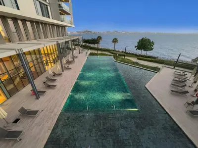 a swimming pool in front of a building next to the water at Bluewaters 5BR Panoramic Eye of Dubai Views Near JBR Beach in Dubai