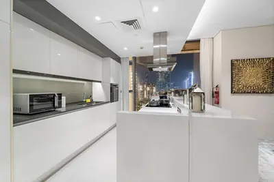 a kitchen with white cabinets and a view of the city at Bluewaters 5BR Panoramic Eye of Dubai Views Near JBR Beach in Dubai