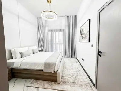 a white bedroom with a bed and a window at Upgraded 1BDR APT in Mag 930 , AL Merkadh Dubai in Dubai