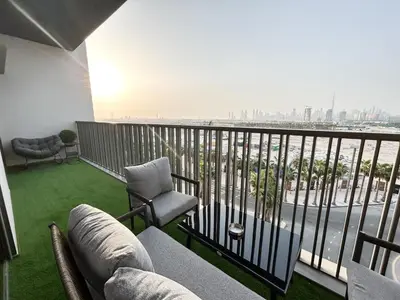 a balcony with a couch and chairs and a view of the city at Upgraded 1BDR APT in Mag 930 , AL Merkadh Dubai in Dubai