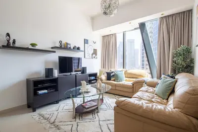 a living room with two couches and a glass table at Frank Porter - Silverene Tower B in Dubai