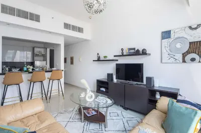 a living room with a couch and a tv at Frank Porter - Silverene Tower B in Dubai