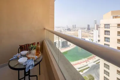 a balcony with a table with a view of a city at Frank Porter - Lakeside Tower C in Dubai