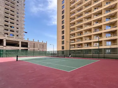 a tennis court in front of a large building at Frank Porter - Lakeside Tower C in Dubai