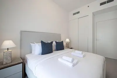 a bedroom with a large white bed with blue pillows at Cozy 1 - Bedroom Retreat in DHE in Dubai
