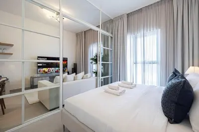 a bedroom with a large white bed and a mirror at Cozy 1 - Bedroom Retreat in DHE in Dubai
