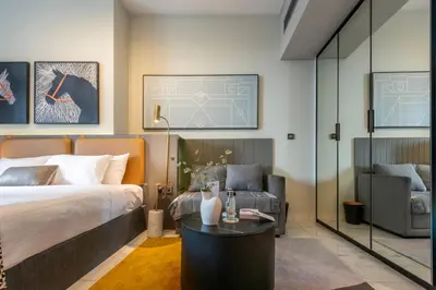 a bedroom with a bed and a table and a chair at Canal View Studio - 10 min to Dubai Mall - MAG 318 in Dubai