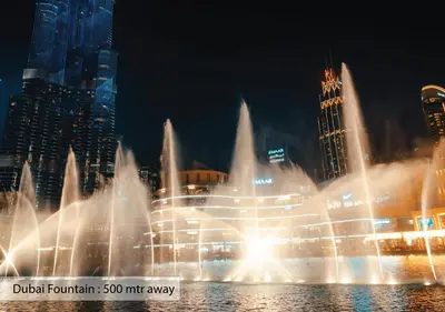 a water fountain in front of a city at night at Luxury Escapes - Elegant 3BR Apt with 4 Balconies in 29 Blvd in Dubai