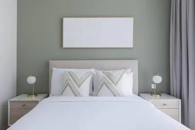 a bedroom with a white bed with two lamps at Palace Residence Dubai Creek Harbour 1 Bd Apt in Dubai