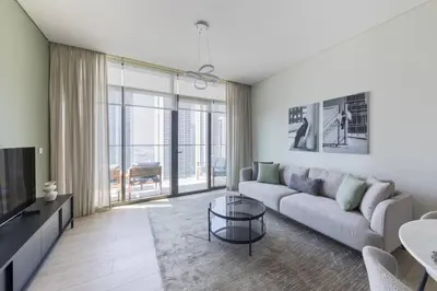 a living room with a couch and a tv at Palace Residence Dubai Creek Harbour 1 Bd Apt in Dubai
