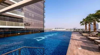 a swimming pool on the side of a building at Damac Hills Carson studio on Golf Course in Dubai Marina