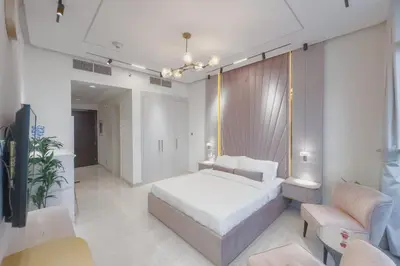 a bedroom with a bed and a couch and chairs at Damac Hills Carson studio on Golf Course in Dubai Marina
