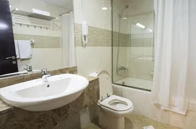 a bathroom with a sink and a toilet and a shower at The Flex Partition Room Near Mall of the Emirates in Dubai