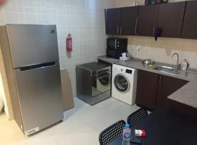 a kitchen with a refrigerator and a washing machine at The Flex Partition Room Near Mall of the Emirates in Dubai