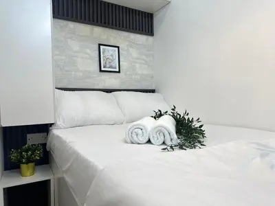 a bedroom with a white bed with towels on it at The Flex Partition Room Near Mall of the Emirates in Dubai
