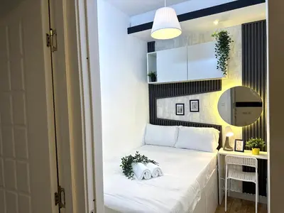 a small bedroom with a white bed and a mirror at Executive Suite Room in Barsha 1 Near MOE Metro in Dubai