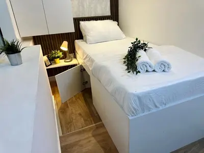a bedroom with a white bed with towels on it at Escape Partition Room in Barsha 1 Near MOE Metro in Dubai