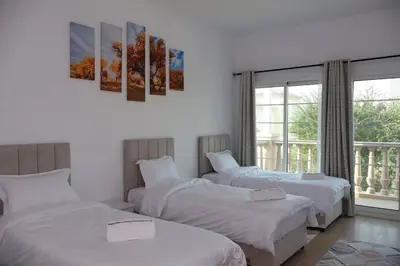 a bedroom with two beds and a window at Specious 2BR VILLA WITH MAIDROOM AND HUGE GARDEN IN JVT DUBAI in Dubai